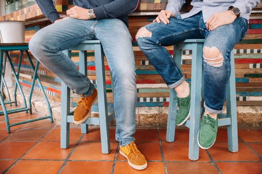 Orange Natural World sneakers on café stools